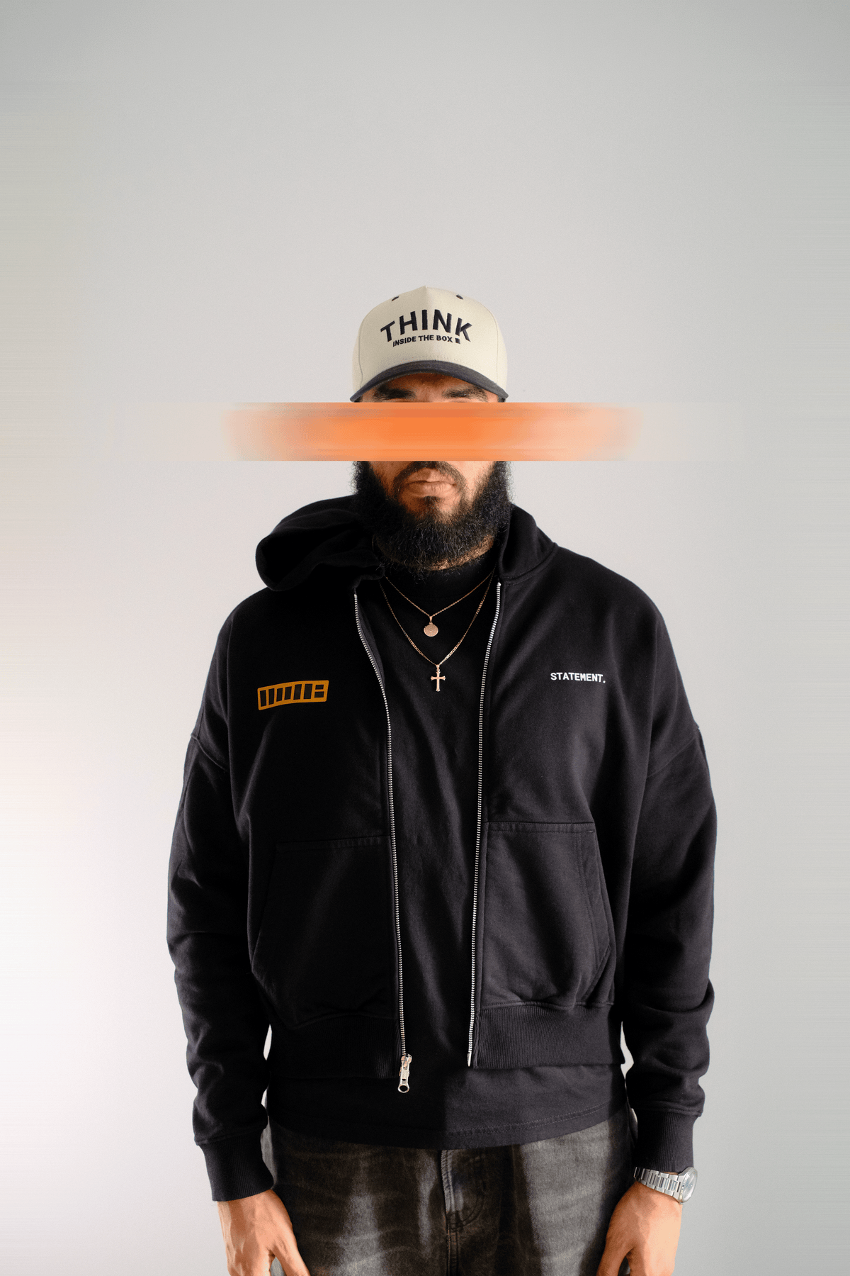 Person wearing a black hoodie with visible branding on a plain background
