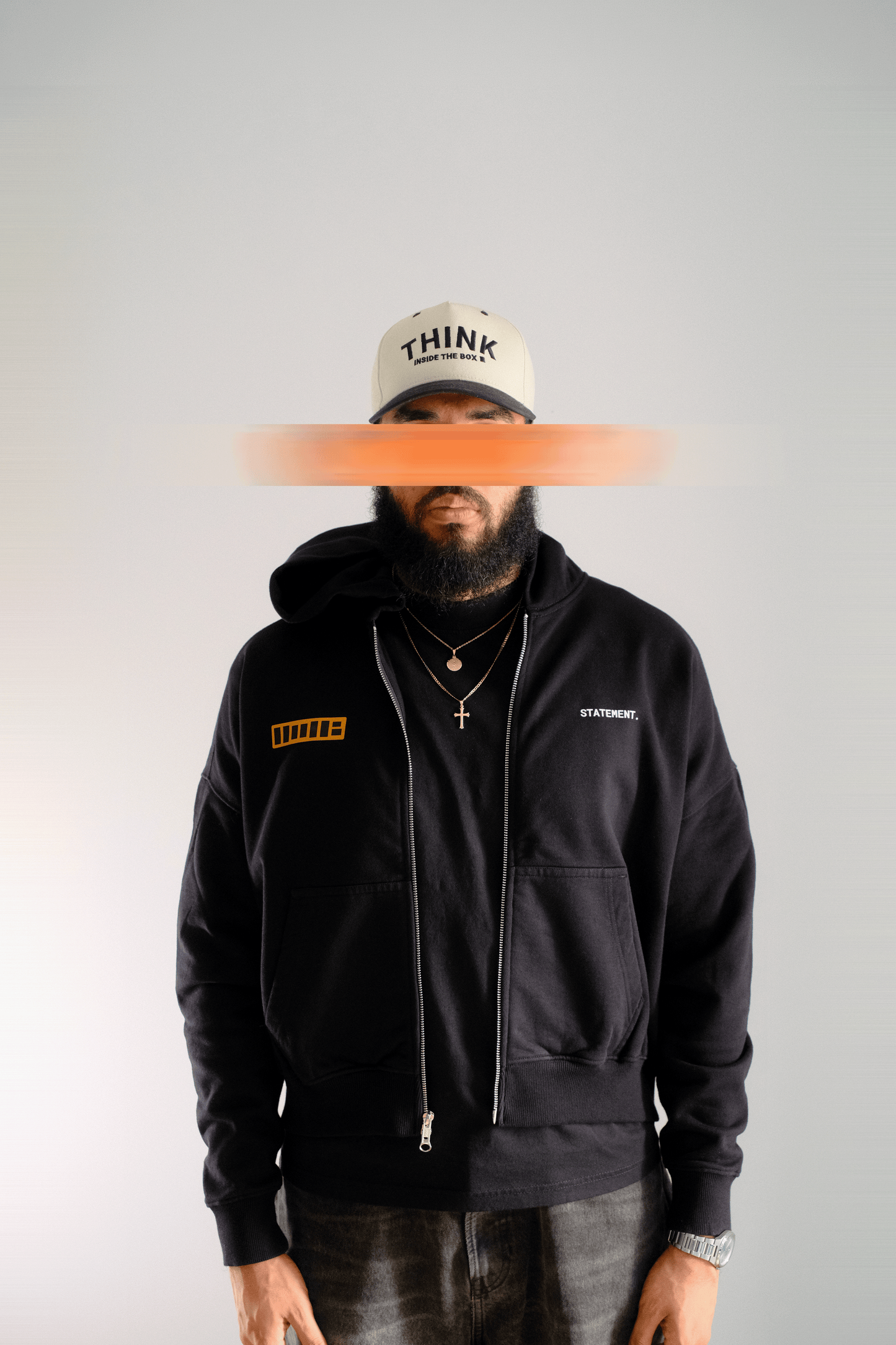 Person wearing a black hoodie with visible branding on a plain background