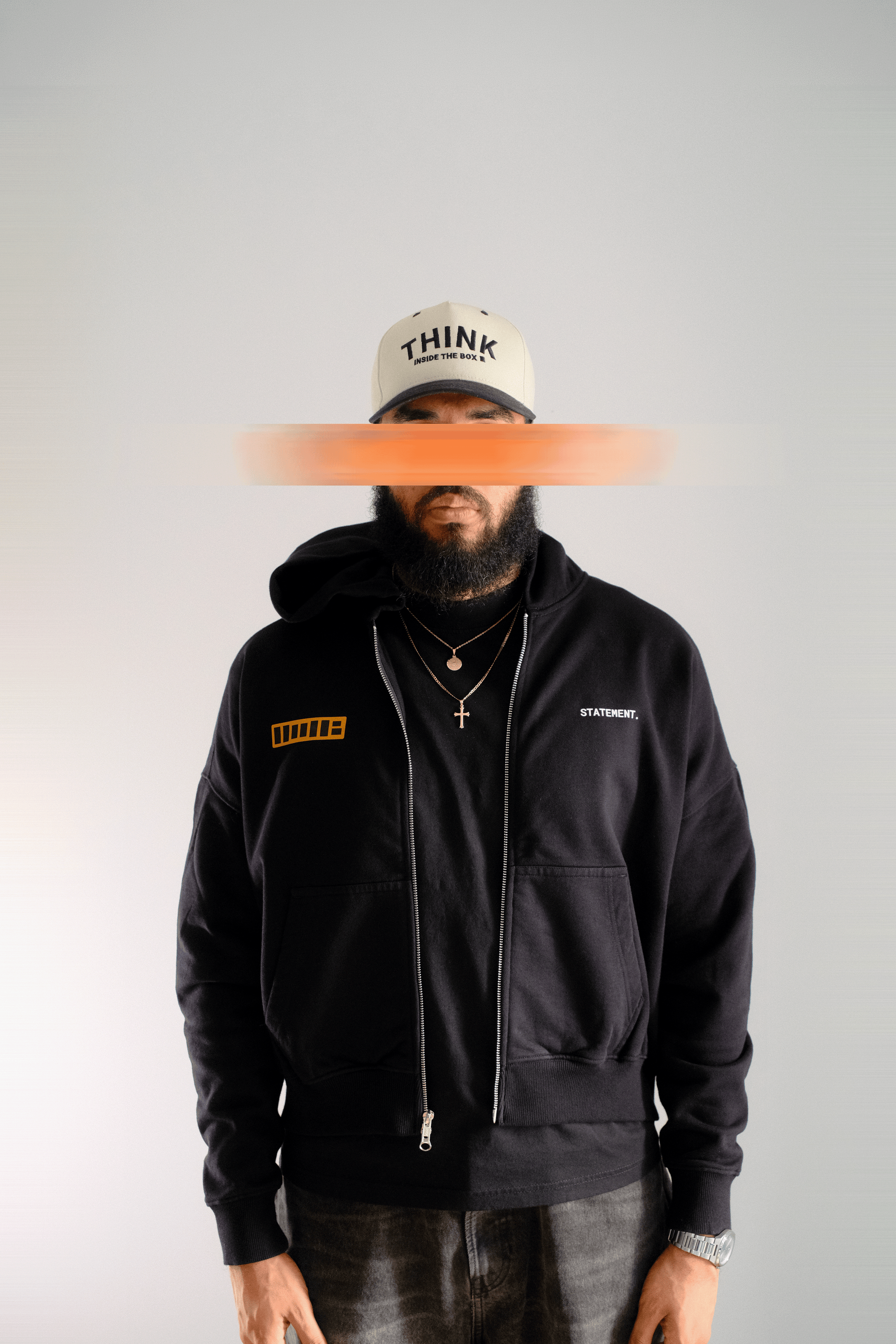 Person wearing a black hoodie with visible branding on a plain background